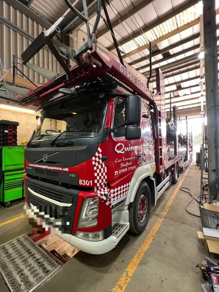 Car transporter truck fitted with vehicle camera system in workshop